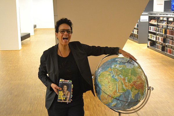 Mo Asumang mit ihrem Buch in der Bielefelder Stadtbibliothek. - © Raphael Vásquez