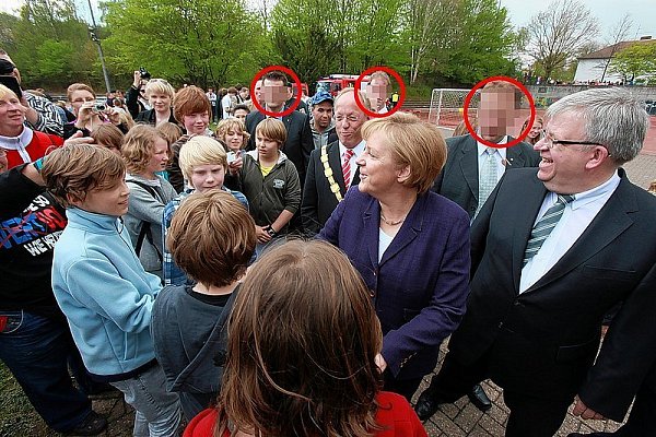 Beim Angela-Merkel-Besuch Ende April in Bethel hielten sich die Bielefelder Personenschützer (rote Kreise) dezent im Hintergrund. Direkt hinter der Kanzlerin, Pastor Ulrich Pohl (r.) und Pit Clausen (Kette) nehmen sie jede Regung in der Menge wahr. - © FOTO: ANDREAS ZOBE