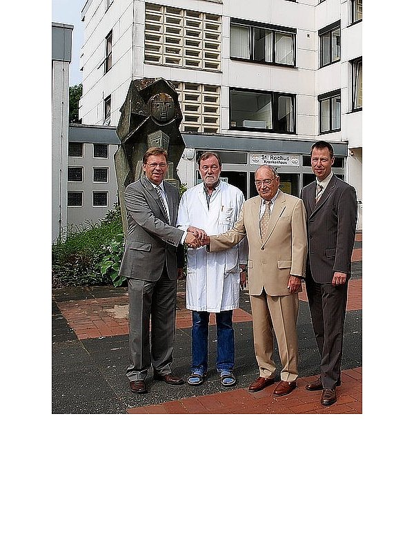 Vor der Plastik des heiligen Rochus und unter den Augen von Verwaltungsleiter Stefan Kruse (r.) vollzogen Reinhard Spieß, Heinz Becker und Dr. Michael Arndt (v. l.) mit einem Händedruck die Spendenübergabe. - © FOTO: JOSEF KÖHNE