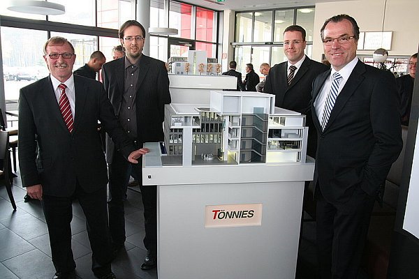 Konzernchef Clemens Tönnies, seine Neffen Robert und Clemens sowie Geschäftsführer Josef Tillmann (v. r.) vor dem Modell des neuen Verwaltungsgebäudes. - © FOTO:MARIONPOKORRA-BROCKSCHMID
