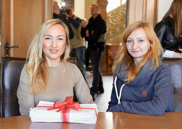 Hülya Arslan (v.l.) und ihre Mitschülerin Regina Breitenbücher, mit der zum Paket geschnürten Petition am Tisch des Oberbürgermeisters sitzend. - © Peter Unger