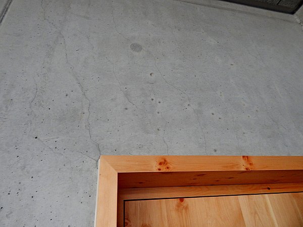 Die Risse, die ausgehend von der oberen Türecke und rechts davon zu sehen sind, sollen Setzungsrisse des Betons sein. - © Gunter Held