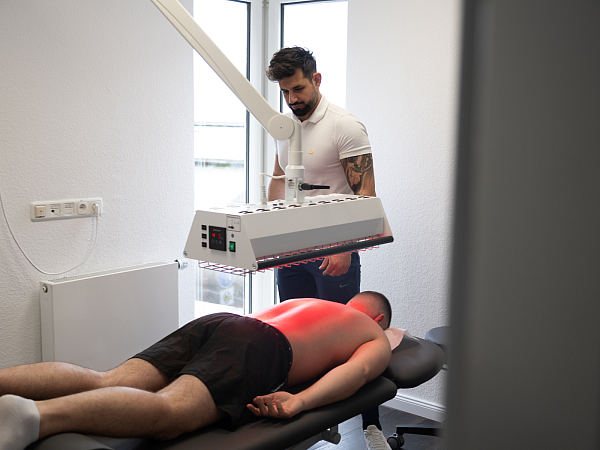 Der Rücken eines Patienten wird mit Wärme behandelt.