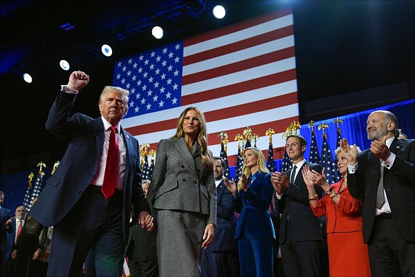 Der republikanische Präsidentschaftskandidat Donald Trump gestikuliert neben seiner Ehefrau Melania bei einer Wahlparty im Palm Beach Convention Center. - © Evan Vucci/AP/dpa