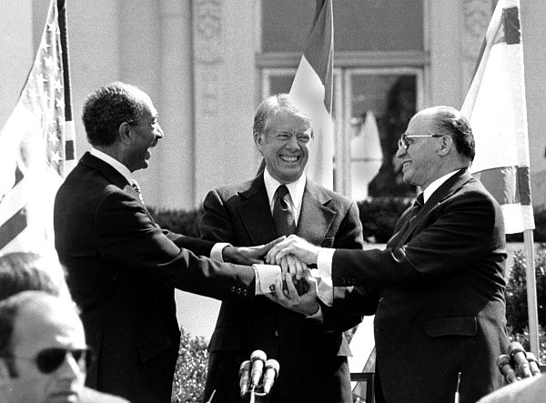 Der ägyptische Präsident Anwar Sadat (l.), US-Präsident Jimmy Carter (M.) und der israelische Ministerpräsident Menachem Begin reichen sich auf dem Nordrasen des Weißen Hauses die Hände, nachdem sie den Friedensvertrag zwischen Ägypten und Israel am 26. März 1979 in Washington unterzeichnet haben. - © dpa