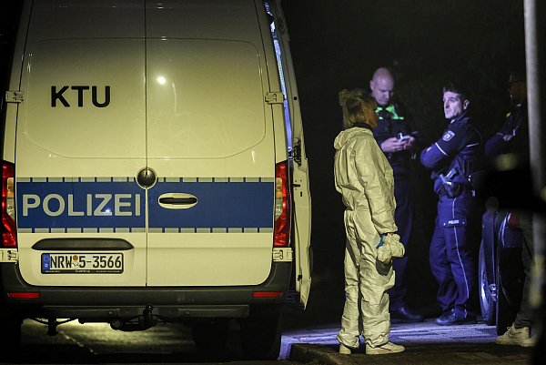 Eine Beamtin der Spurensicherung steht im Spurensicherungsanzug am Fahrzeug der KTU (Kriminaltechnische Untersuchung), im Hintergrund Polizeibeamte. - © Christoph Reichwein/dpa