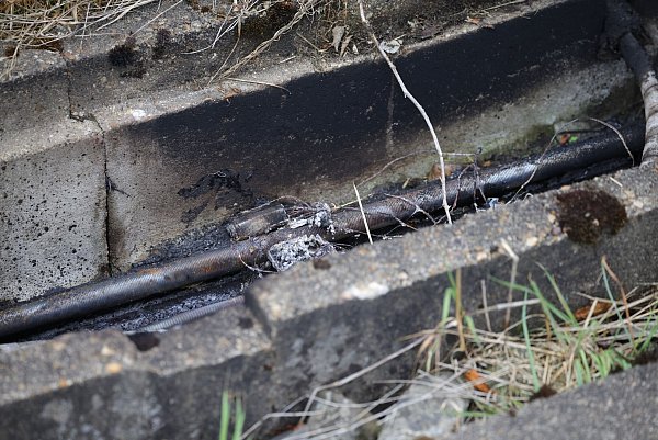 Brandspuren sind am Rande von Gleisen in einem Betontrog zu sehen - darin verlaufen Kabel. Auf die wichtige Nord-Süd-Strecke der Deutschen Bahn ist ein weiterer Brandanschlag verübt worden. - © Christoph Reichwein/dpa