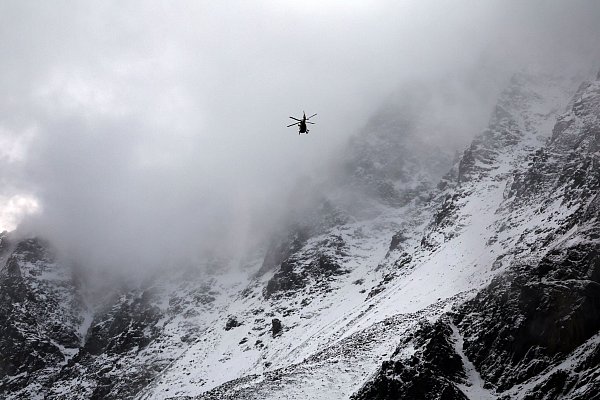 Ein Hubschrauber der Bergrettung fliegt auf der Suche nach zwei vermissten Bergsteigern vor dem mit Schnee bedeckten Ortler Gebirge. - © Karl-Josef Hildenbrand/dpa