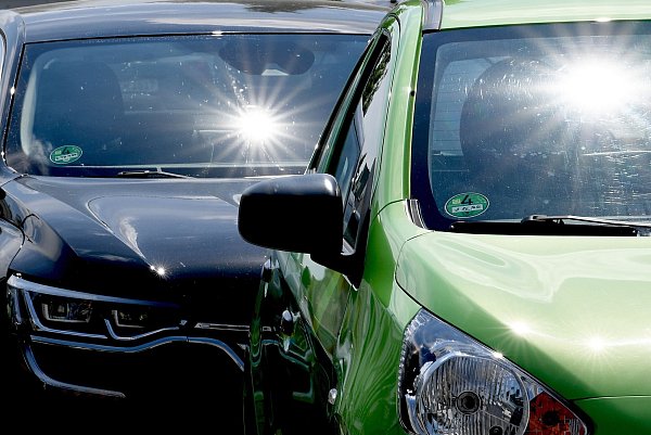 Autos in der prallen Sonne und hohen Temperaturen: Innerhalb weniger Minuten wird es in den Wagen gefährlich heiß. - © Britta Pedersen/dpa-Zentralbild/