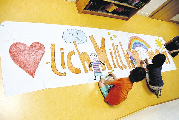 Festvorbereitung: Kinder malen ein buntes „Herzlich-Willkommen-Banner" für den großen Jubiläumstag. - © Kita Brede