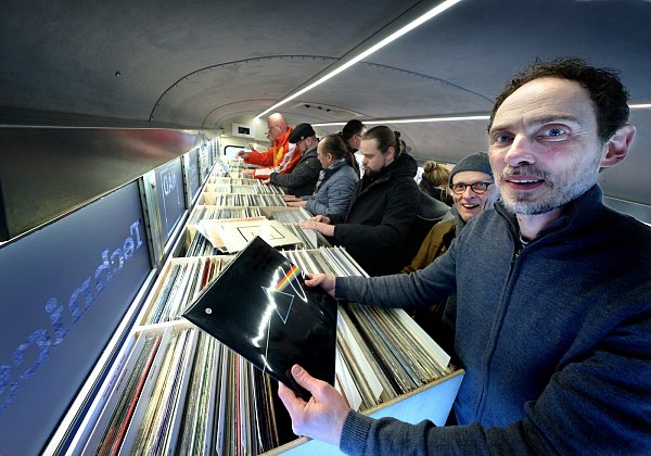 Michael Lohrmann (r.) mit zahlreichen stöbernden Musikfreunden in seinem Bus. In der Hand hält es das Pink-Floyd-Album „Dark Side of The Moon“. - © Andreas Frücht