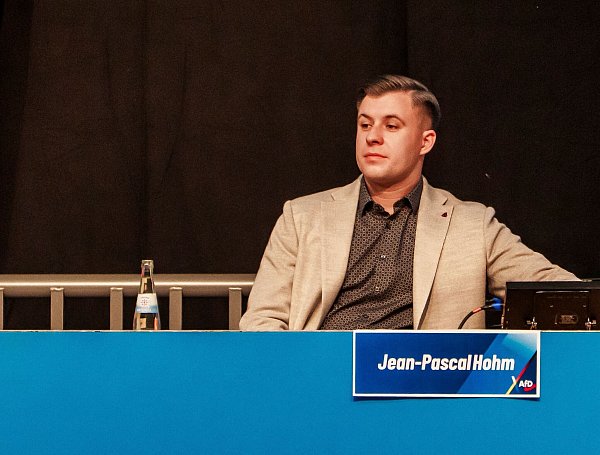 29.11.2025, Hessen, Gießen: Jean-Pascal Hohm, Chef der neuen AfD Jugendorganisation «Generation Deutschland», sitzt nach seiner Wahl auf dem Podium. Mehrere Tausend Demonstranten protestierten am Samstag gegen die Neugründung einer AfD-Jugendorganisation. Die als gesichert rechtsextremistisch eingestufte Vorgängerin „Junge Alternative“ hatte sich durch Selbstbeschluss aufgelöst. Auf der Gründungsveranstaltung in den Hessenhallen sollen auch die beiden Co-Bundesvorsitzenden sprechen. Foto: Andreas Arnold/dpa +++ dpa-Bildfunk +++ - © Andreas Arnold/dpa