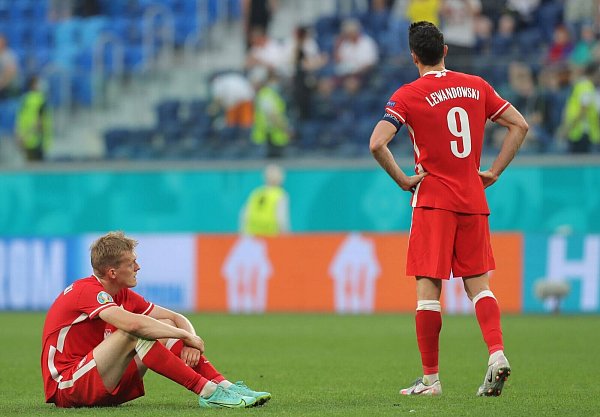 Polens Robert Lewandowski (r) steht nach Abpfiff enttäuscht auf dem Rasen. - © Igor Russak/dpa