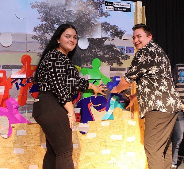 „Jeder Schüler ist anders, wie ein Puzzlestück.“ Leonora Vokri und Ferris Dörner kleben stellvertretend für die Klasse 9b ein Puzzlestück an. - © Städtische Realschule Steinheim