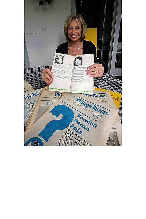 Annette Steikert hält das Buch der Deutschen Olympiamannschaft von 1972, links ist sie abgebildet. Davor liegen die Ausgaben der Zeitungen aus dem Olympischen Dorf. - © FOTO: PLASSHENRICH