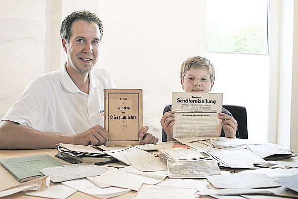 Antike Dokumente: Daniel Bucksch und sein Sohn Luca (11) schauen sich die alten Dokumente aus den Kriegsjahren an. Sie haben sie bei den Renovierungsarbeiten im Schäferwagen gefunden. - © Isabelle Helmke