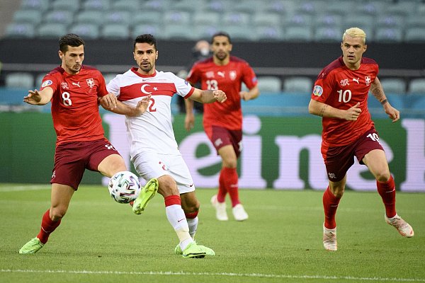 Der Schweizer Remo Freuler (l) im Zweikampf mit Zeki Celik aus der Türkei. - © Jean-Christophe Bott/KEYSTONE/dpa
