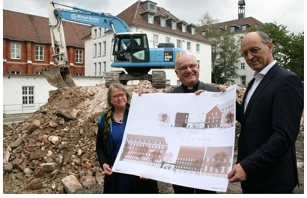 Diözesanbaumeisterin Emanuela von Branca (v. l.), Domkapitular Monsignore Michael Menke-Peitzmeyer und Architekt Thomas Bieling mit den Plänen zum Umbau des Priesterseminars (r.) und Konvikts (l.). Der mittlere Bau hinter dem Bagger ist das Schwesternhaus, das bald abgerissen wird. - © FOTO: HOLGER KOSBAB