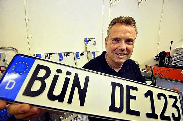 Carsten Körber zeigt, wie ein Bünder Autokennzeichen aussehen könnte. Im Hintergrund Rohlinge mit dem üblichen HF-Kennzeichen. - © FOTO: KARL-HENDRIK TITTEL