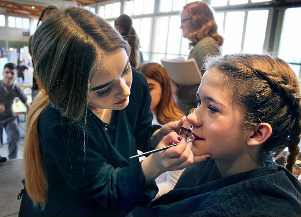 Geschminkt: Die angehende Kosmetikerin Olivia Keyser malt die Lippen der 13-jährigen Karolin mit einem Pinsel nach. - © Melanie Wigger