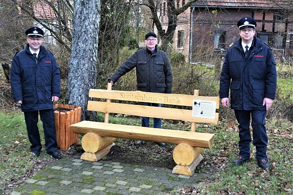 Ortsheimatpfleger Rudi Koch hat eine neue Bank am Ort, wo früher das Spritzenhaus stand, dem Leiter der Feuerwehr Altenbeken Rainer Hartmann (l.) und Oberbrandmeister Sebastian Kaiser übergeben. - © Winfried Marx