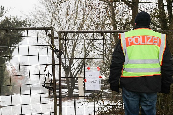Ein Polizist vor dem Grundstück bei Arnstein. In einem Gartenhäuschen auf dem Grundstück sind am Sonntag sechs Teenager tot gefunden worden. - © picture alliance / Daniel Karmann/dpa