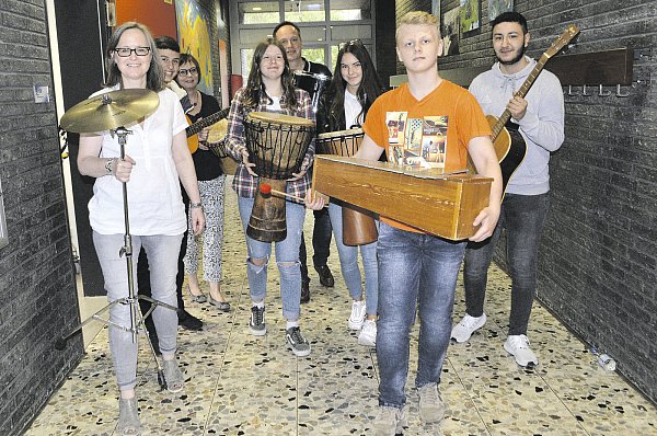 Umzug des Musikraums: THS Konrektorin Anja Bainski (v.l.), Ilaz, Konrektorin der Johannes-Rau-Schule Martina Todte, Mia, THS- Rektor Daniel Norkowski, Angelina, Biyan und Niklas helfen beim Transport von Musikinstrumenten in den anderen Trakt des Schulzentrums, der bisherigen Johannes-Rau-Hauptschule. - © Sibylle Kemna