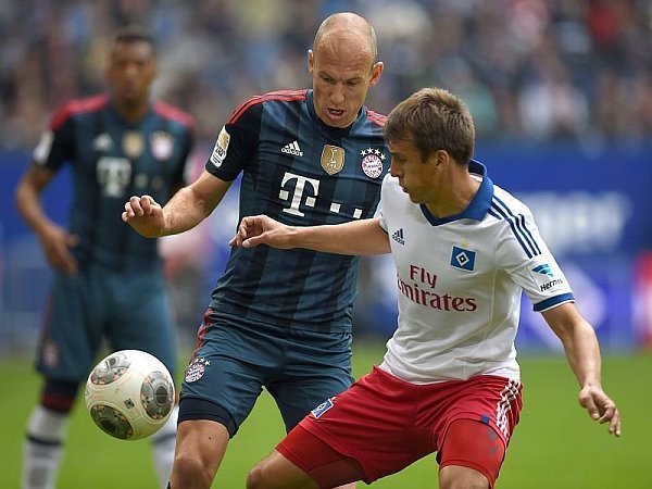 Robert Tesche im Mai 2014 im Dress des Hamburger SV im Zweikampf mit Bayern Münchens Arjen Robben. - © FOTO: DPA