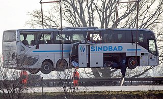 Ein Kran hebt den verunglückten Reisebus zurück auf die Fahrbahn. - Klaus-Dietmar Gabbert/dpa