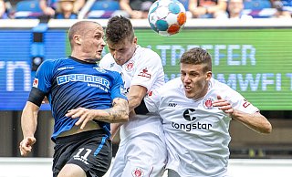 SCP-Stürmer Sven Michel (l.) verpasst den Ball, doch Pauli-Rechtsverteidiger Adam Dzwigala (M.) erwischt das Spielgerät mit voller Wucht und köpft das Leder zum 1:1 ins eigene Tor. - picture alliance/dpa