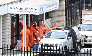 In Schutzanzügen wurden die Schulen gesäubert und der Sand entsorgt. - Lukas Coch/AAP/dpa