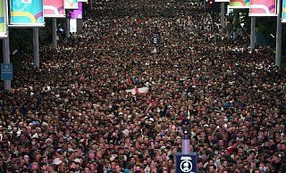 Fans feiern vor dem Wembley-Stadion, nachdem sich England für das Finale der Fußball-EM qualifiziert hat. - Foto: Zac Goodwin/PA via AP/dpa