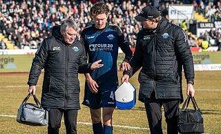 SCP-Mannschaftsarzt Matthias Porsch (l.) und Physiotherapeut Torben Glenny begleiten den verletzten Calvin Brackelmann beim Zweitliga-Gastspiel in Ulm vom Platz. - IMAGO/Eibner