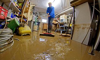 Mit dem Schrubber rückte Sylvia Vogt dem schlammigen Wasser in ihrem Keller zu Leibe. - Andreas Sundermeier