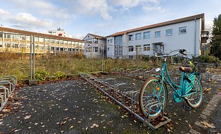 Auf dieser Fläche entsteht der Erweiterungsbau für die Realschule Schloß Neuhaus. Rechts steht das Bestandsgebäude der Schule, links ist die Sertürnerschule zu sehen. - Niklas Tüns