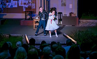 Schneiderin Monika (Judith Brink) und Kai Weberknecht (Alexander Becker) tanzen zu Rockmusik auf dem Laufsteg. - Julia Spiekerkötter