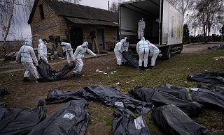 Freiwillige laden die Leichen von in Butscha getöteten Zivilisten auf einen Lastwagen, um sie zur Untersuchung in ein Leichenschauhaus zu bringen (Archivbild). - Rodrigo Abd/AP/dpa