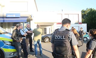 Während Zoll-Beamte im Inneren kontrollieren, warten weitere Beamte sowie Experten der Bauaufsicht und des Ausländeramts vor dem Gebäude. - Jobst Lüdeking