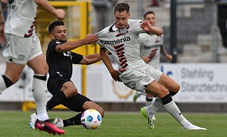 SCP-Innenverteidiger Visar Musliu (l.) ist wieder einsatzbereit und könnte es am Mittwochabend wieder mit Leverkusens Supertalent Florian Wirtz zu tun bekommen, den er hier im Testspiel gegen Bayer per Textilbremse stoppt. - picture alliance