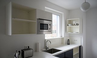 Eine Küche in einem möblierten Wohnraum in einem Neubau. - Christophe Gateau/dpa