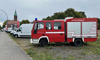 Im Gütersloher Stadtteil Avenwedde reiht sich ein Feuerwehrwagen in die angebotenen Gebrauchtwagen eines Autohauses ein. - Christian Bröder