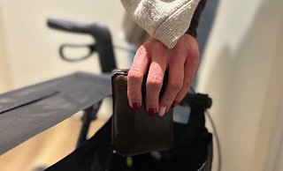 Der Diebstahl im Fall der 91-jährigen Frau in einem Gütersloher Bus hat sich vermutlich wie in dieser nachgestellten Szene abgespielt. Mit einem Schal über der Hand hat die Täterin die Geldbörse aus dem Rollator entwendet. - Christian Bröder