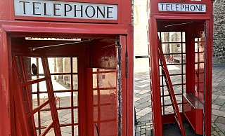 Die hölzerne Tür der englischen Telefonzelle ist komplett abgebrochen worden, sie lehnt innen. - Jens Reichenbach