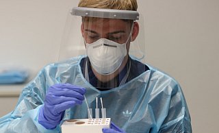 Medizinstudent Simon Ziemer taucht die Abstriche in Pufferlösung. Die wird später auf den Schnelltest geträufelt. Im Gegensatz zu PCR-Tests können die Proben noch an der Oststraße ausgewertet werden. - David Knapp