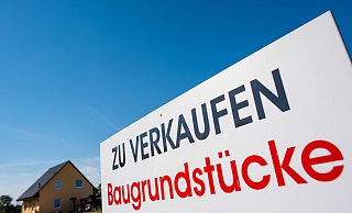 Ein Schild mit der Aufschrift «zu verkaufen - Baugrundstücke». Die Zahl der Immobilienkäufe im Kreis Herford steigt wieder leicht an. - dpa
