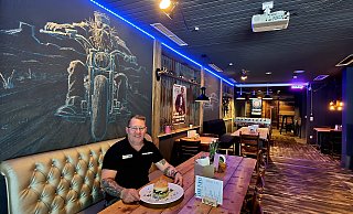 Peter Pöhlker sitzt in seinem neuesten "Schätzchen", dem "Good Times", vor einem Burger - um ihn herum lässiger US-Biker-Style. - Kurt Ehmke