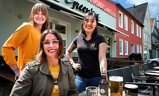 „Wir sind noch da!" Auch Carolin Kramme (von links), Kathrin Dudding und Lan Nguyen dürfen draußen, im Biergarten vor dem Pub „Green’s", ab dem heutigen Donnerstag wieder Gäste bewirten. - Andreas Frücht