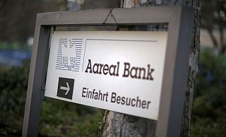 Ein Schild weist auf die Einfahrt für Besucher der Aareal Bank hin. - Foto: picture alliance / dpa