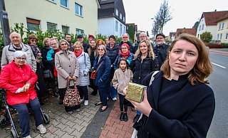 Melanie Schröder (rechts) zeigt den Stolperstein, der jetzt in Gedenken an ihren Großvater in den Bürgersteig an der Diebrocker Straße in Herford eingelassen wurde. Knapp 30 Teilnehmer – darunter auch einige Verwandte von August Schröder.?Foto: Daniel Salmon - Daniel Salmon