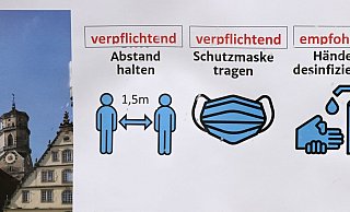 Ein Hinweisschild mit Corona-Regeln in der Stuttgarter Innenstadt. - Foto: Bernd Weißbrod/dpa